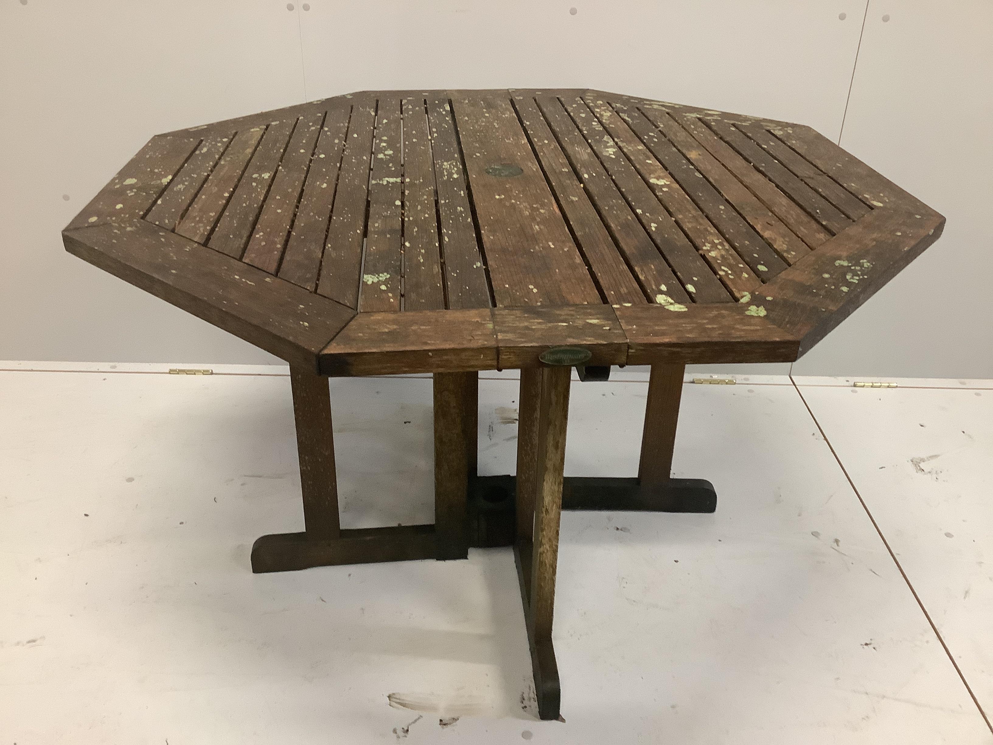 A weathered octagonal teak garden table, width 120cm, height 73cm and four chairs